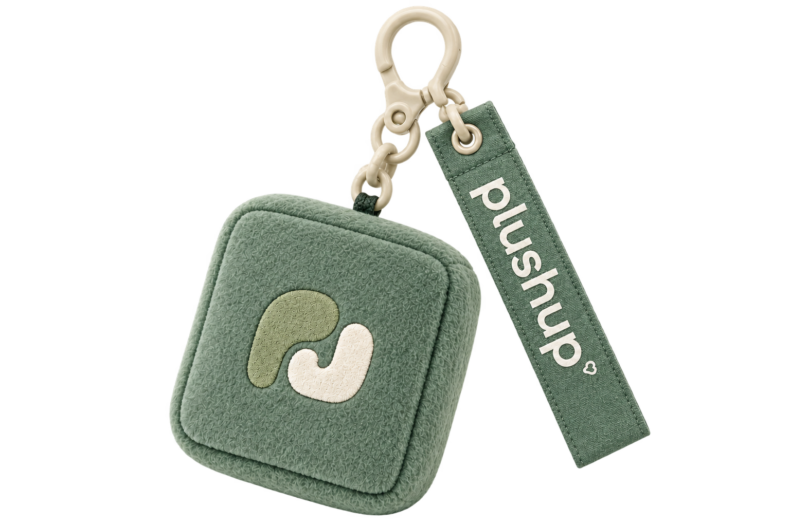 Sage-green plush keychain with embroidered monogram, clipped to a tote bag